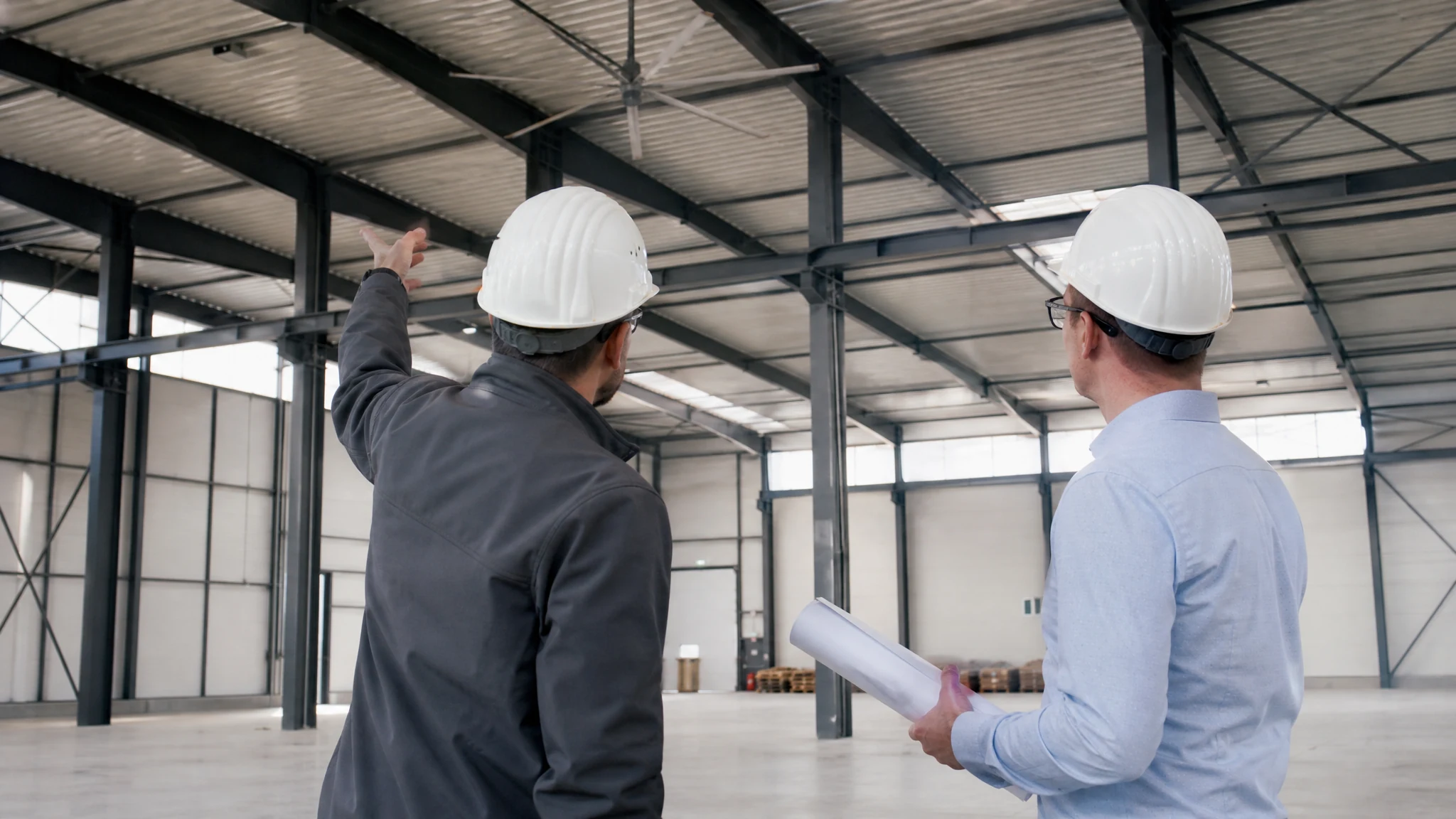 Industrial airflow specialists reviewing warehouse structure and plans